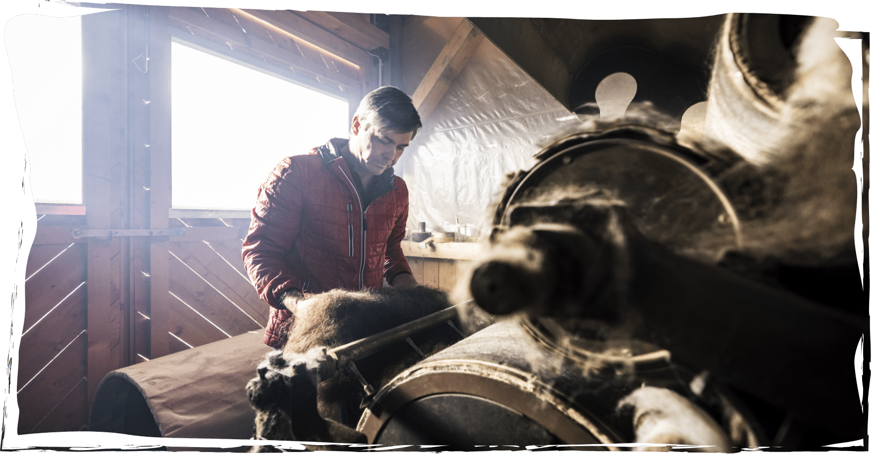 Bernhard beim Bedienen der historischen Wollfilzmaschine auf seiner AlpakaAlm.